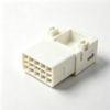Off‑white molded plastic electrical connector housing with multi‑grid terminal cavity and side locating posts