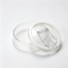 Round clear plastic container with white outer ring and transparent hinged flap lid
