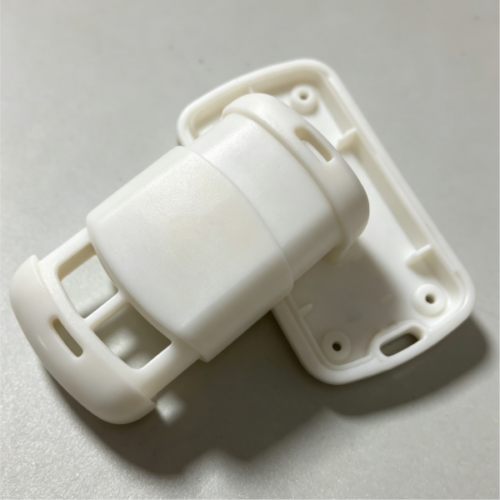 White plastic connection housing with connector body, slot structure, mounting holes and snap-fit ribs, custom molded part