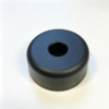 Custom molded bumper base in black, a round pad with a center bore on a white background