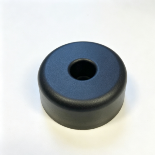 Custom molded bumper base in black, a round pad with a center bore on a white background