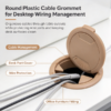 Round plastic cable grommet managing cables through a desk cutout with the flip cover open