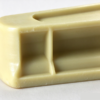 Nylon slide block underside close up, with the cored pockets and the center rib between them in view