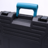 Hard tool box close up on the blue carry handle, with a latch and the ribbed shell beside the handle recess