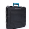 Hard tool box standing closed in black with a blue carry handle, a recessed panel and two front latches