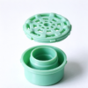 Filter cover assembly shown apart, the mesh cap lifted off the threaded neck of the cylindrical base