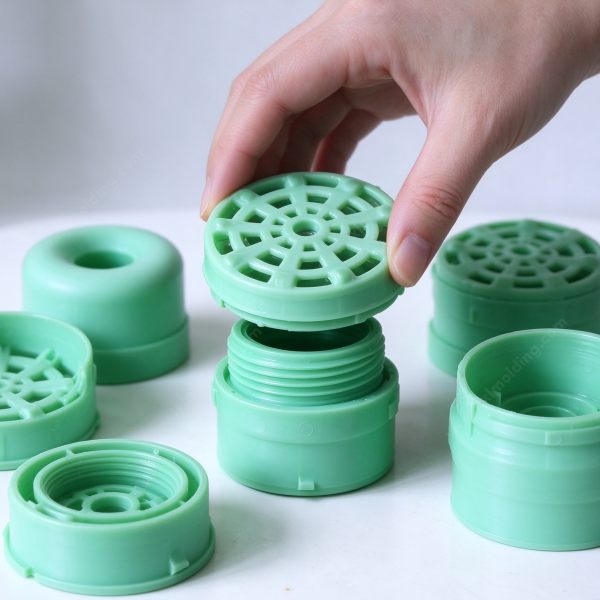 Filter cover assembly in green, a hand setting the mesh cap down onto the threaded base