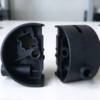 Split connector shell, one half with its window and ribs, the other showing the wall port and bore