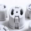 Molded push-in snap bushing in white, the round wall, latch leg and center bore in close view