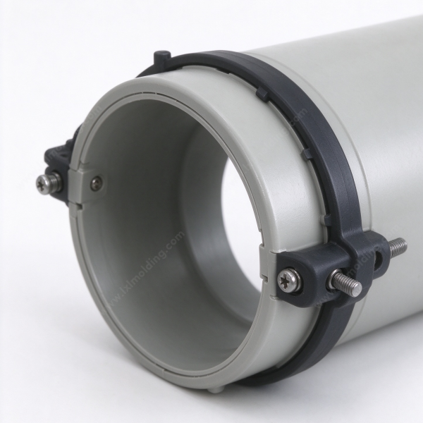 Plastic band clamp bolted around the rim of a gray tube, the two ears drawn together by a threaded stud and a nut
