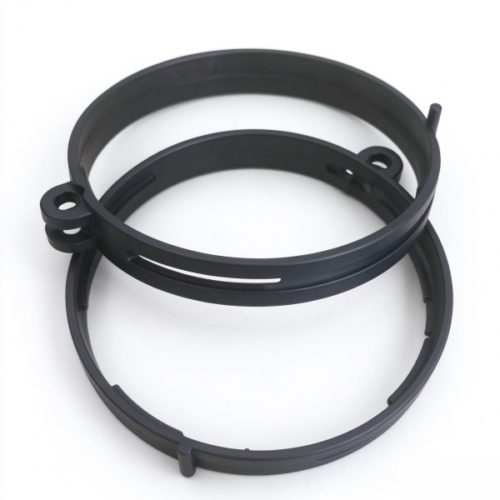 Plastic band clamp in black, three split rings stacked with the stacked ears, the long slot and the locator pip in view